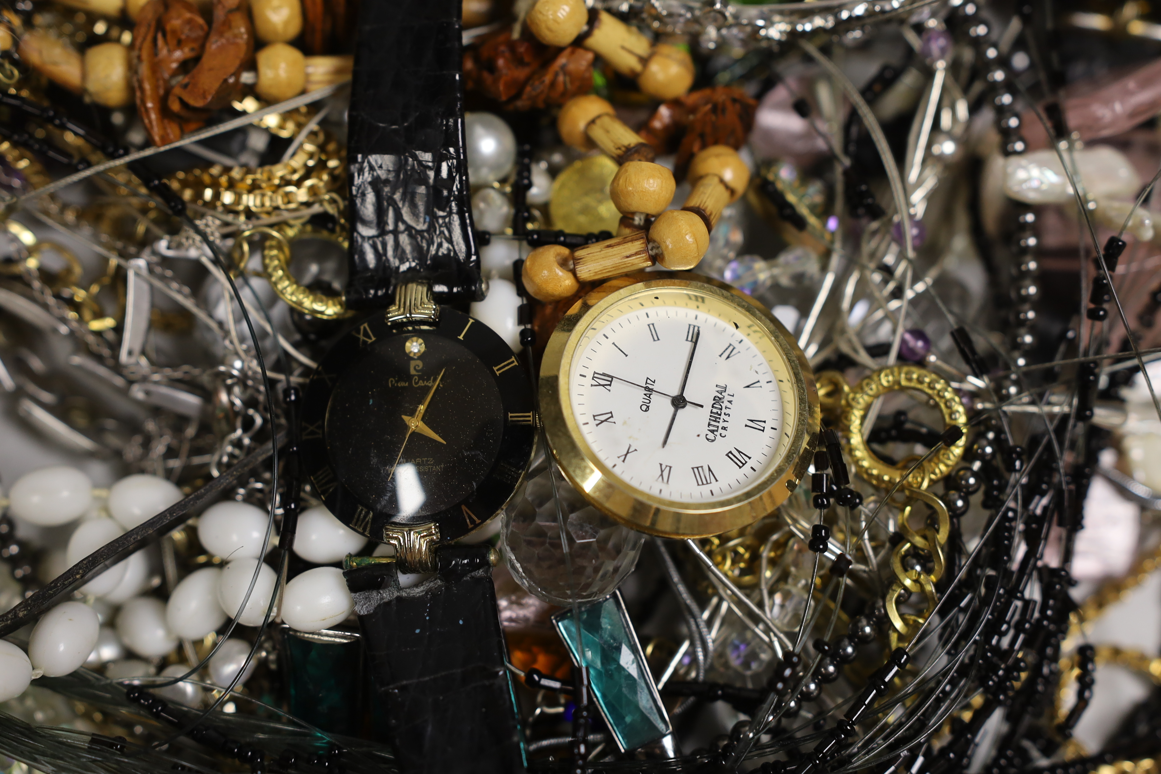 A box of costume jewellery including silver brooches and pendants.